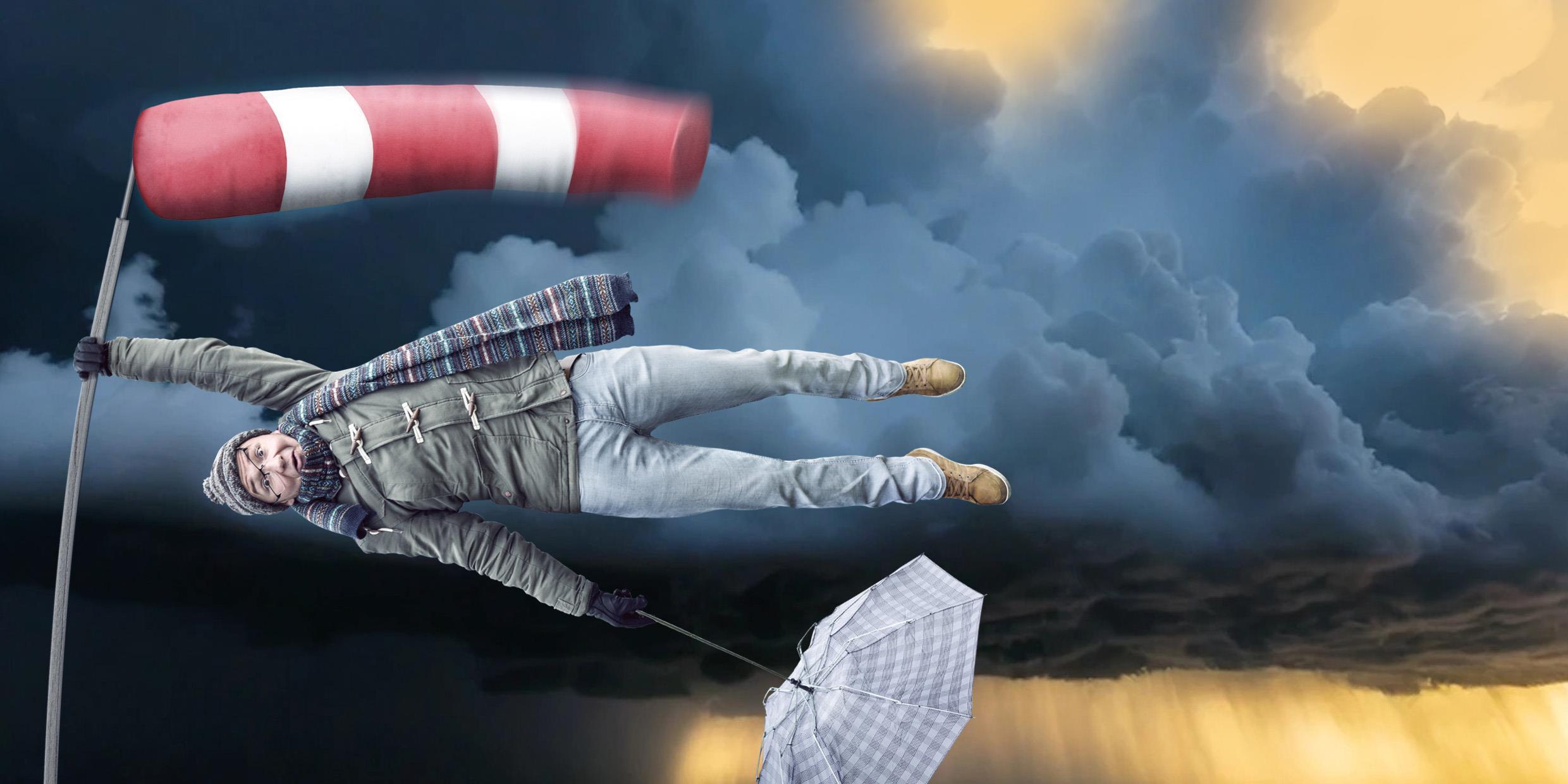 Ein Mann, der sich im Sturm an einer Windfahne festhält